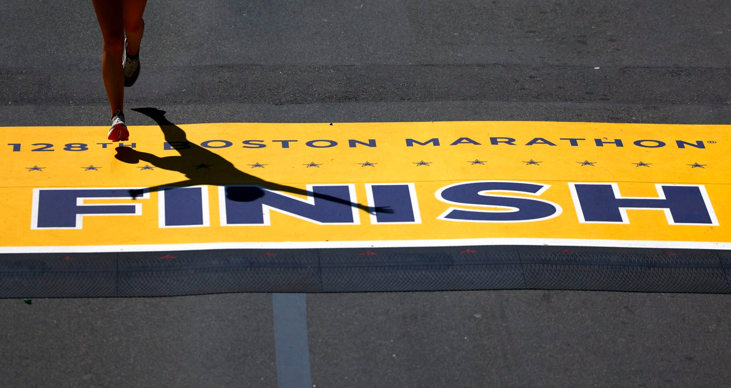 Un corridore taglia il traguardo durante la maratona di Boston lunedì 15 aprile 2024.