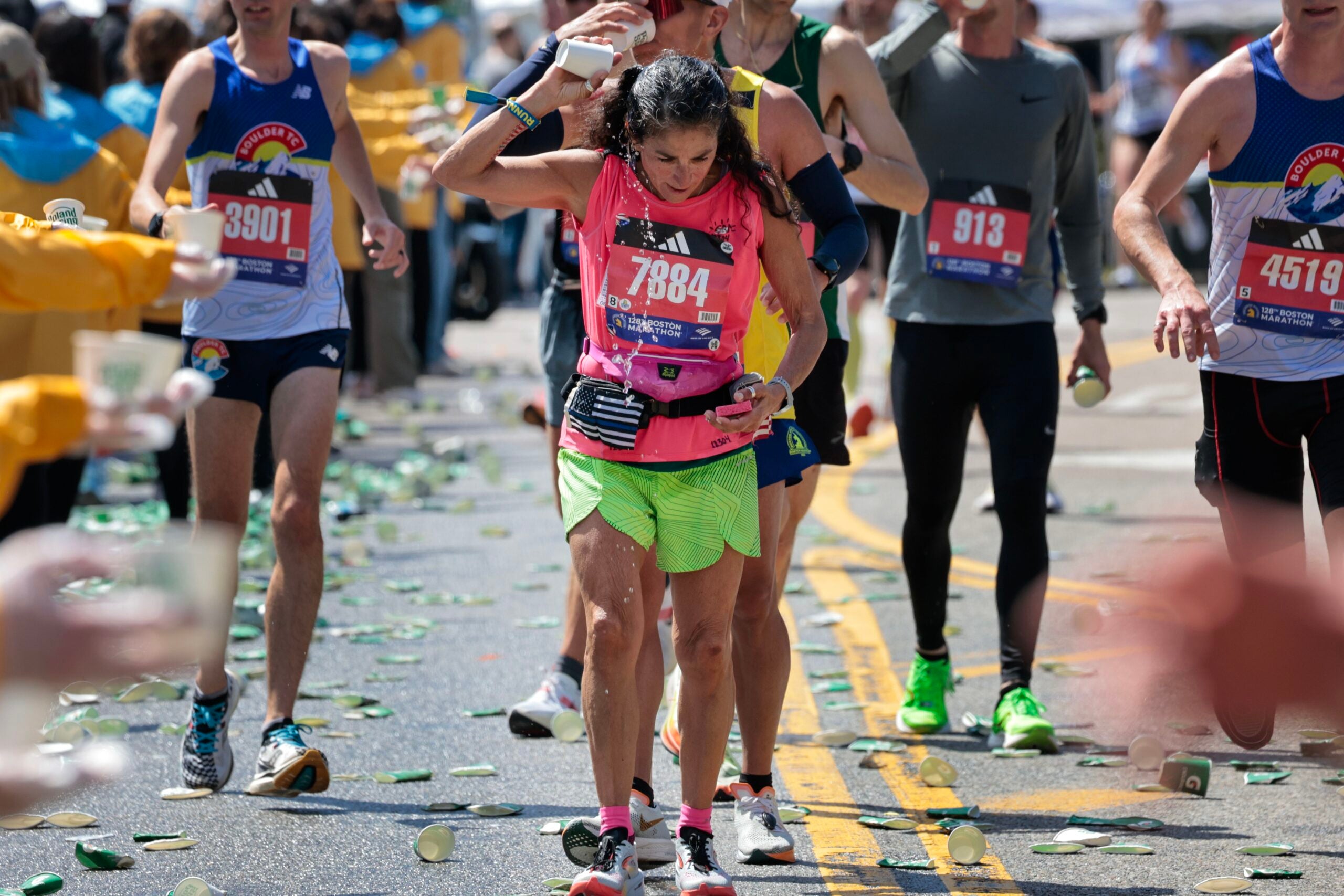 Patty Monge pours water on herself after cresting Heartbreak Hill during the Boston Marathon on Monday, April 15, 2024.
