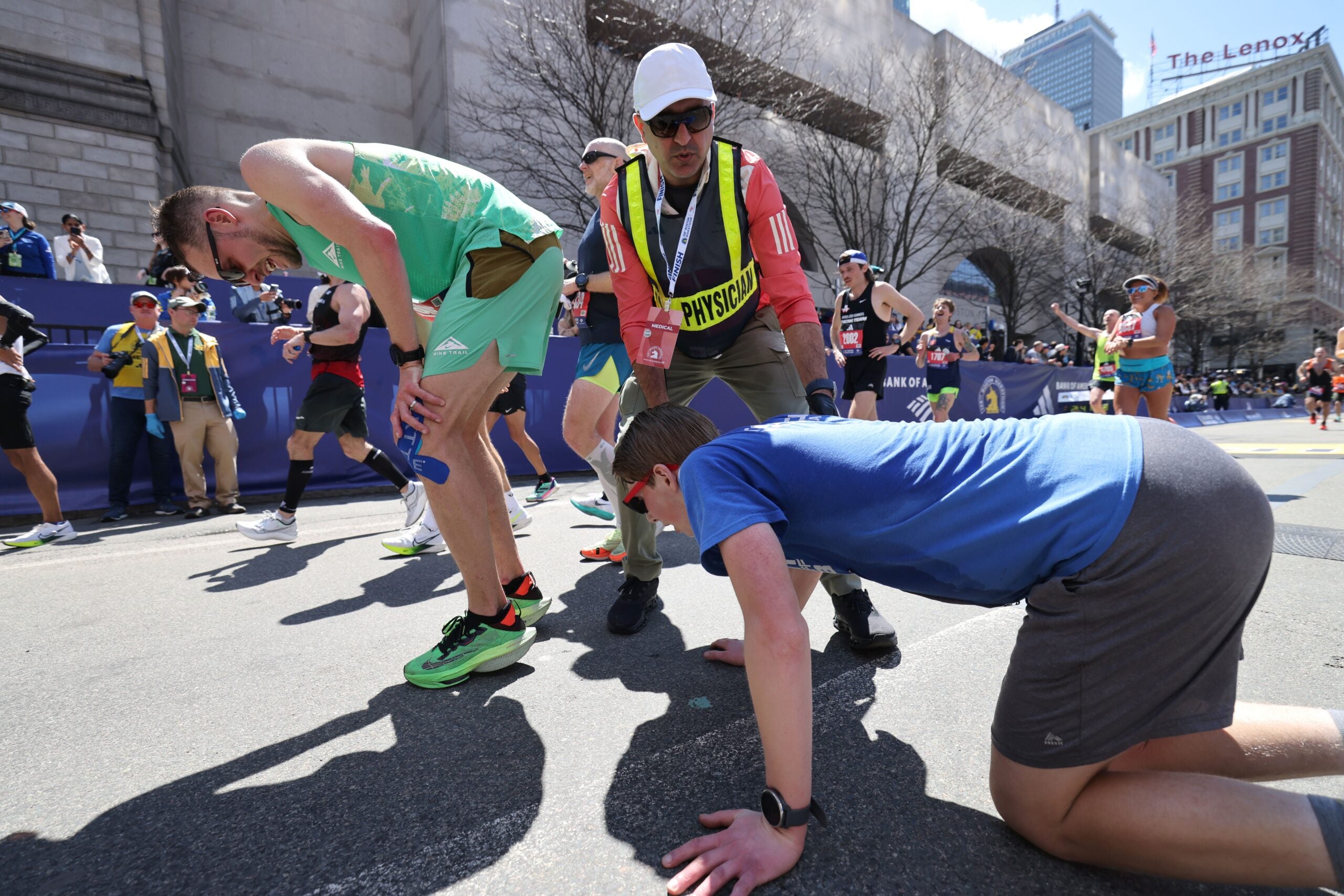 A medical professional helps two runners during the 128th Boston Marathon on April 15, 2024.