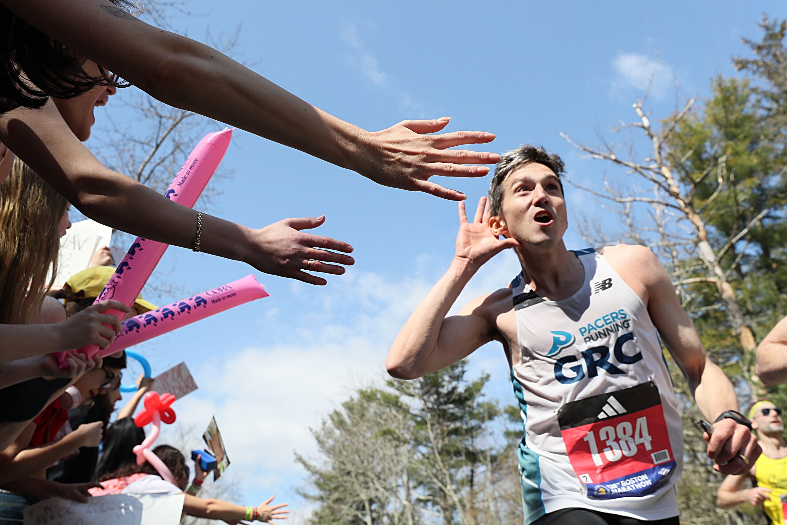 A runner motioned for the Wellesley College students to cheer louder as he passed Wellesley College.