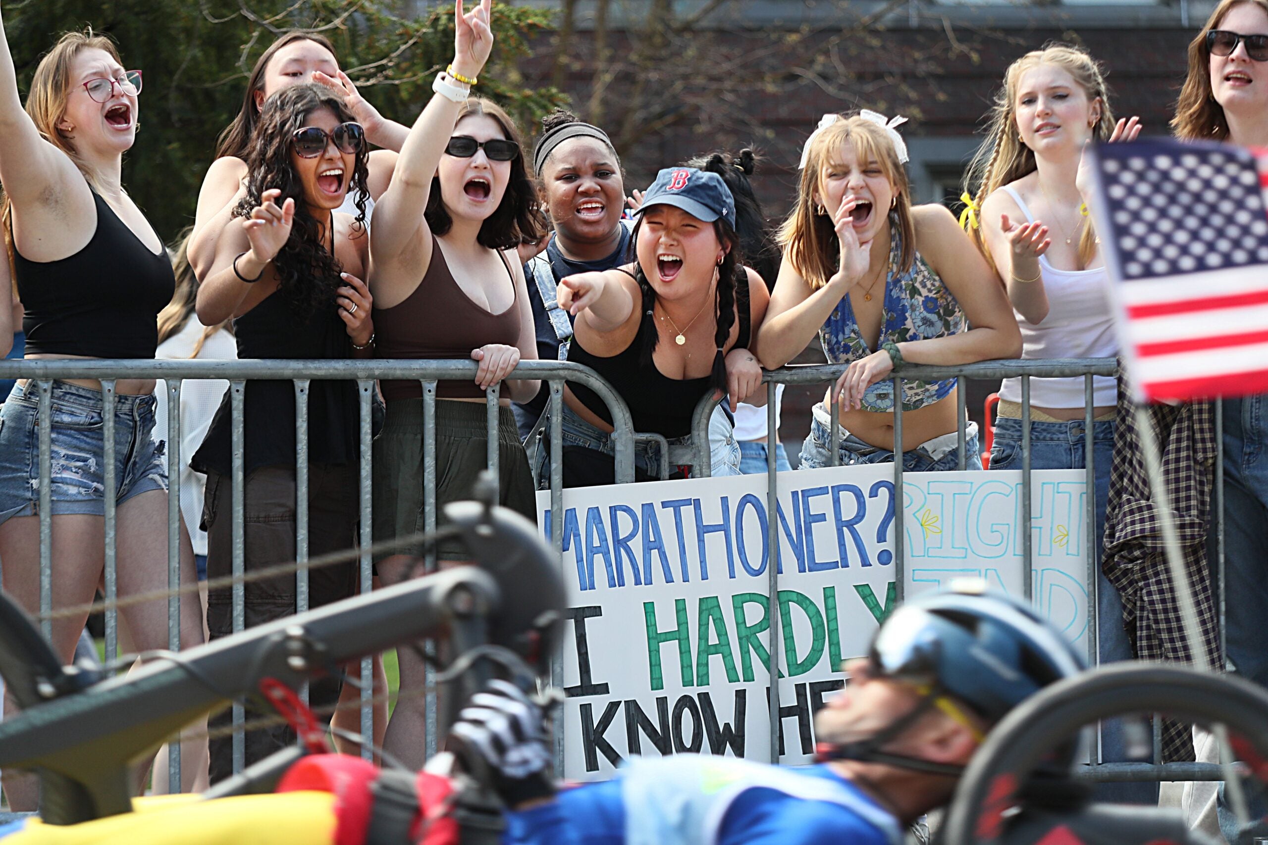 Wellesley College students cheer as the wheelchair and handcycle racers pass by the scream tunnel along the course of the Boston Marathon on Monday, April 15, 2024.