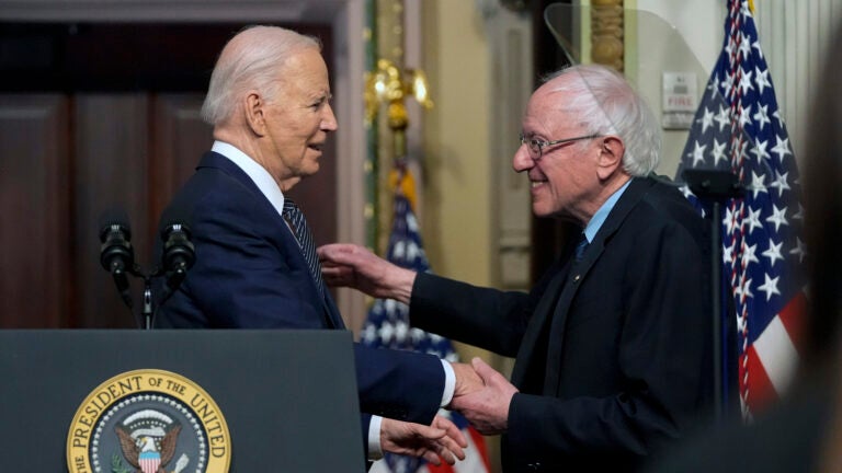 President Joe Biden stands with Sen. Bernie Sanders, I-Vt.