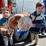 Gabriel Kauffman, 4, and his brother, Theodore, 6, demonstrate a total solar eclipse at a NASA booth at the Great Lakes Science Center in Cleveland.