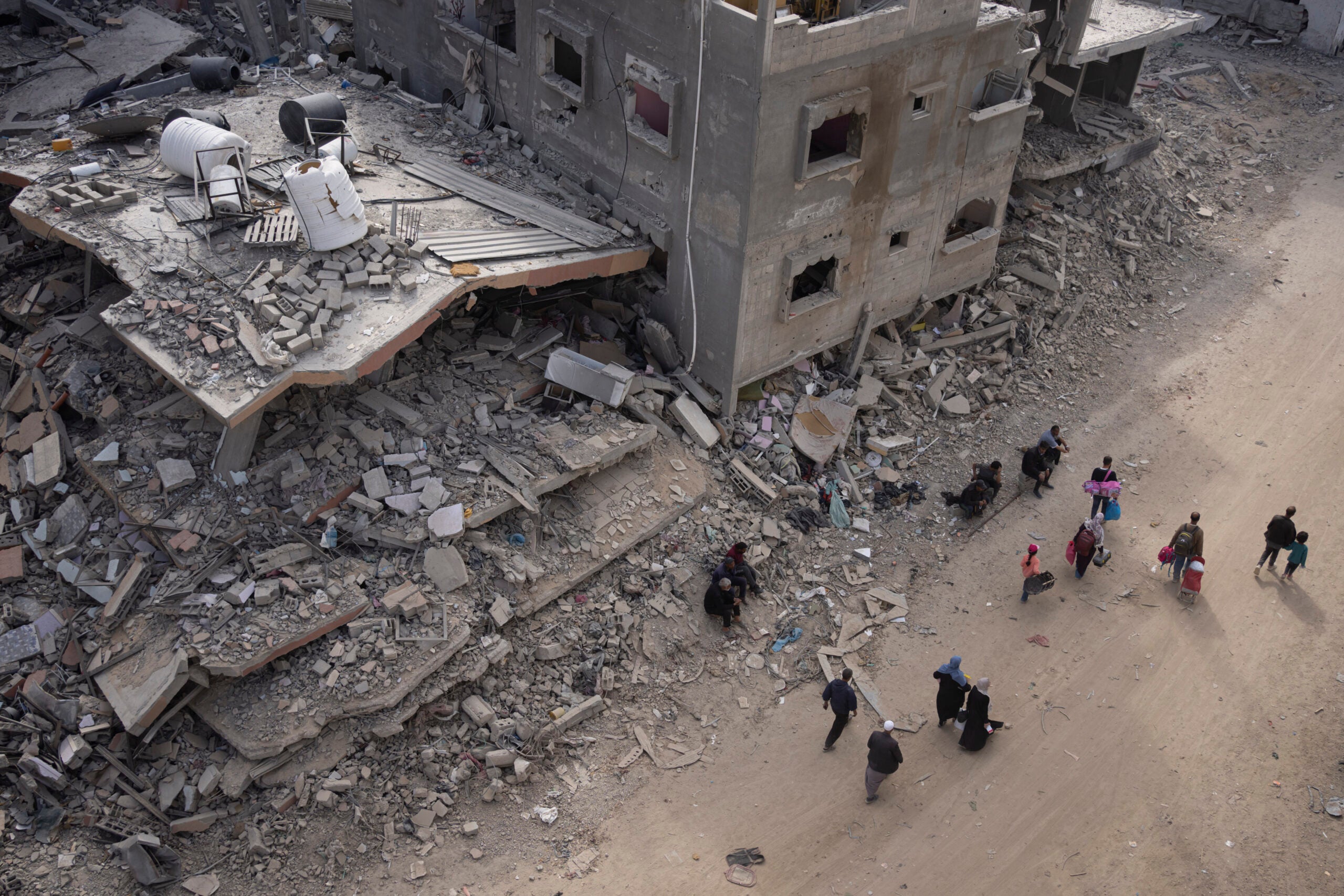 Palestinians walk through the destruction in the wake of an Israeli air and ground offensive in Khan Younis. 