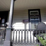 A person stands on the porch of the international headquarters of the Satanic Temple in Salem, Mass.
