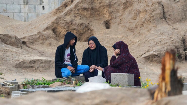 Palestinians visit the graves of their relatives who were killed in the war.