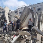 Palestinians look at the destruction after an Israeli airstrike in Rafah.