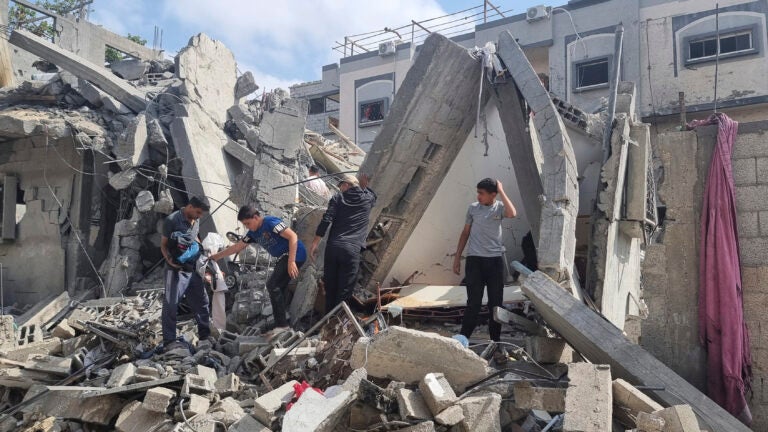 Palestinians look at the destruction after an Israeli airstrike in Rafah.