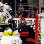 David Pastrnak of the Bruins slips the puck past Carolina Hurricanes goaltender Frederik Andersen into the top of the net for a goal during the first period.