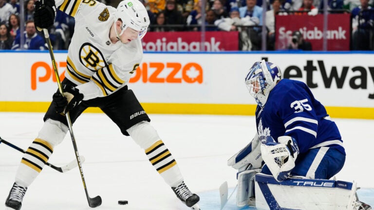 Boston Bruins' Mason Lohrei (6) tries to shoot between his legs against Toronto Maple Leafs goaltender Ilya Samsonov (35) during first-period action in Game 4 of an NHL hockey Stanley Cup first-round playoff series in Toronto, Saturday, April 27, 2024.