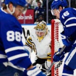 Boston Bruins goaltender Jeremy Swayman, center, watches the action as Toronto Maple Leafs' William Nylander (88) and Mitch Marner (16) look for the puck during second-period action in Game 4 of an NHL hockey Stanley Cup first-round playoff series in Toronto, Saturday, April 27, 2024.