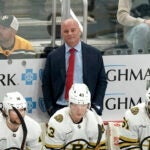 Boston Bruins head coach Jim Montgomery stands behind his bench during the third period of an NHL hockey game against the Pittsburgh Penguins, Saturday, April 13, 2024, in Pittsburgh.
