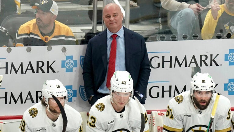 Boston Bruins head coach Jim Montgomery stands behind his bench during the third period of an NHL hockey game against the Pittsburgh Penguins, Saturday, April 13, 2024, in Pittsburgh.