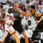 Boston Celtics center Kristaps Porzingis (8) and forward Jayson Tatum (0) defend against Miami Heat center Bam Adebayo (13) during the first half of Game 4 of an NBA basketball first-round game, Monday, April 29, 2024, in Miami.