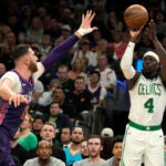 Celtics guard Jrue Holiday shoots in front of Suns center Jusuf Nurkic during a March 9 game in Phoenix.