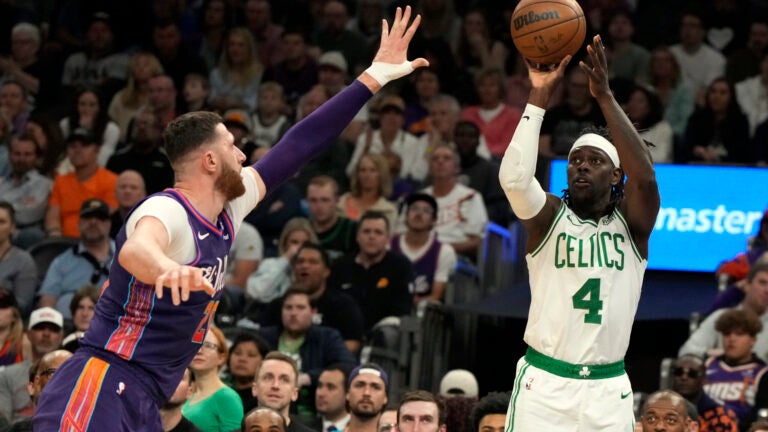 Celtics guard Jrue Holiday shoots in front of Suns center Jusuf Nurkic during a March 9 game in Phoenix.