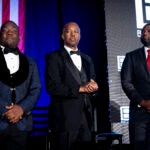 From left, Black Conservative Federation Founder and President Diante Johnson, former U.S. Secretary of Housing and Urban Development Ben Carson, and Rep. Byron Donalds, R-Fla., stand on stage.