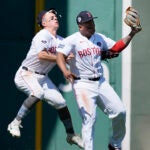 Boston Red Sox's Rafael Devers, center, collides with teammate Tyler O'Neil after making the catch on a pop out by Cleveland Guardians' Estevan Florial as Ceddanne Rafaela, right, looks on during the seventh inning of a baseball game, Monday, April 15, 2024, in Boston.
