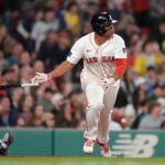 Boston Red Sox's Rafael Devers drops his bat after hitting a two-run double next to Cleveland Guardians' Bo Naylor during the sixth inning of a baseball game Tuesday, April 16, 2024, in Boston.