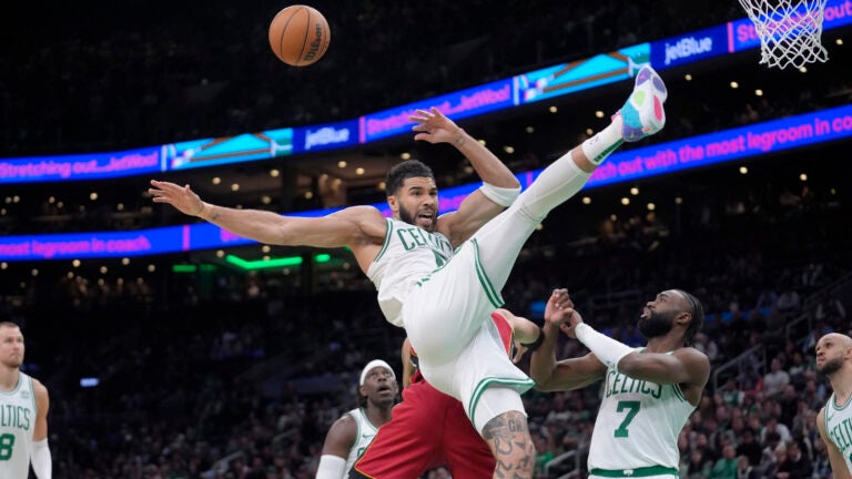 Miami Heat forward Caleb Martin, behind center, fouls Boston Celtics forward Jayson Tatum, front center, in front of Celtics guard Jaylen Brown (7) in the second half of Game 1 of an NBA basketball first-round playoff series, Sunday, April 21, 2024, in Boston.