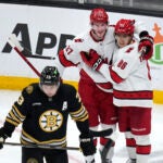 Carolina Hurricanes left wing Teuvo Teravainen (86) is congratulated by Andrei Svechnikov (37) after his goal during the second period of an NHL hockey game, Tuesday, April 9, 2024, in Boston. In foreground is Boston Bruins defenseman Charlie McAvoy (73).
