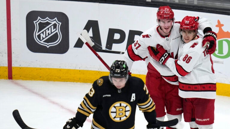 Carolina Hurricanes left wing Teuvo Teravainen (86) is congratulated by Andrei Svechnikov (37) after his goal during the second period of an NHL hockey game, Tuesday, April 9, 2024, in Boston. In foreground is Boston Bruins defenseman Charlie McAvoy (73).