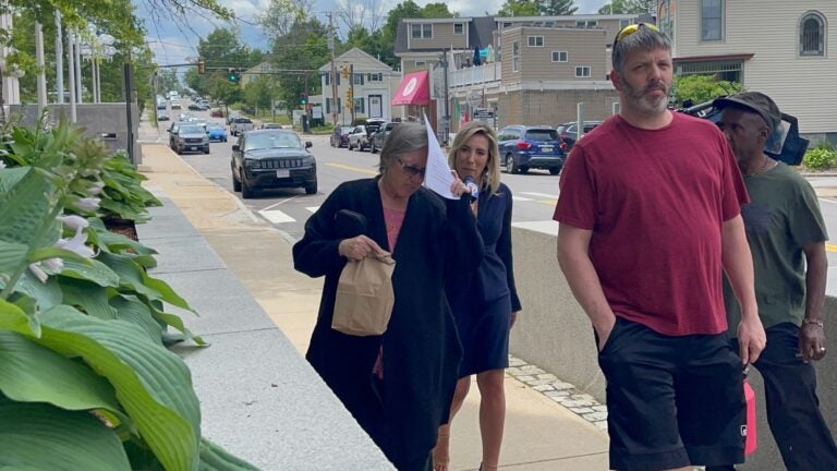 Denise Lodge, 63, covered her face with a printout of the indictment against her as she walked from the federal courthouse in Concord, N.H., in June of 2023 following her arrest on charges related to an alleged scheme to steal and sell donated body parts.
