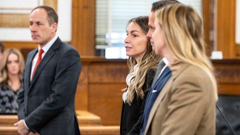 Karen Read stands with lawyers in court during jury selection at Norfolk County Superior Court, Thursday, April 18, 2024, in Dedham.