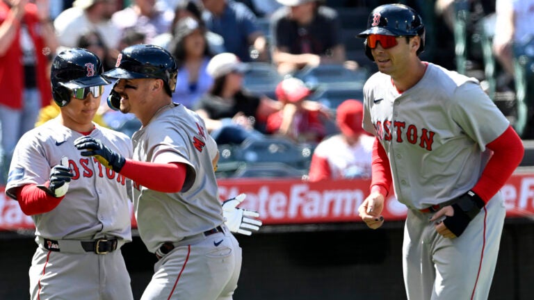 Masataka Yoshida greets Reese McGuire with Triston Casas after McGuire's three-run homer on Sunday in Anaheim against the Angels.