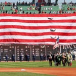 The giant American flag is unfurled over the Green Monster as part of pre game festivities on Patriots Day. The Boston Red Sox hosted the Tampa Bay Rays in an MLB game at Fenway Park.