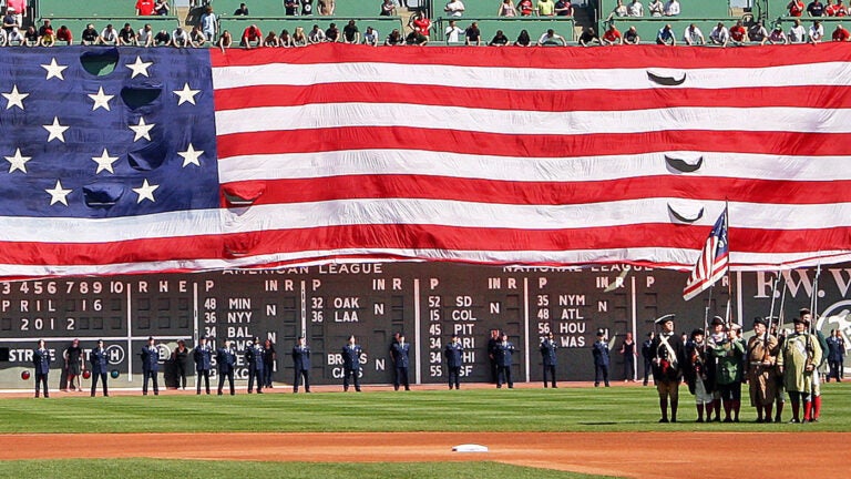 The giant American flag is unfurled over the Green Monster as part of pre game festivities on Patriots Day. The Boston Red Sox hosted the Tampa Bay Rays in an MLB game at Fenway Park.