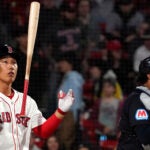 Masataka Yoshida throws his bat in the air.