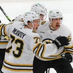 Boston Bruins left wing Brad Marchand (63) celebrates his goal with teammates Charlie McAvoy (73) and Brandon Carlo (25) against the Toronto Maple Leafs during third period action of the NHL Playoffs in game 3, of round 1, at Scotiabank Arena.