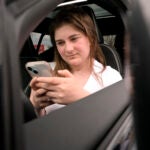 Alexis Bogan uses an AI powered smartphone app to create a audible drink order at a Starbucks drive-thru in Lincoln, R.I.