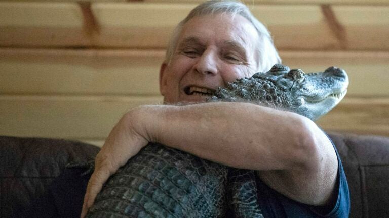 Joie Henney hugs his emotional support alligator.