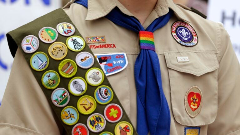 Merit badges and a rainbow-colored neckerchief slider are affixed on a Boy Scout uniform outside the headquarters of Amazon in Seattle.