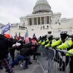 Violent insurrectionists try to break through a police barrier at the Capitol in Washington.
