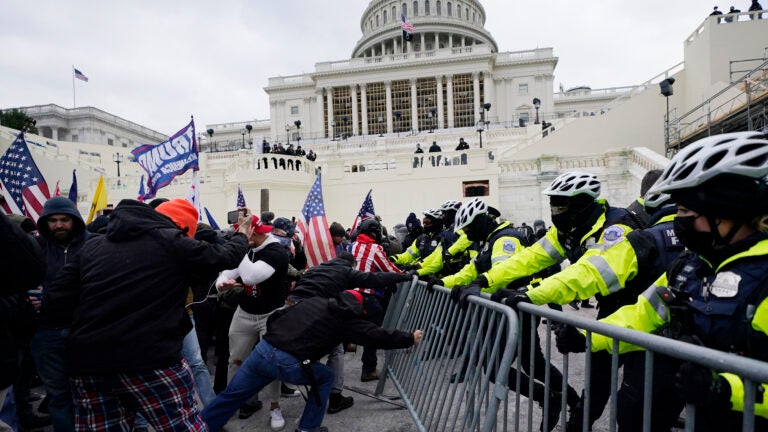 Violent insurrectionists try to break through a police barrier at the Capitol in Washington.