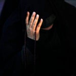 An Iranian woman prays for President Ebrahim Raisi in a ceremony at Vali-e-Asr square in downtown Tehran, Iran.