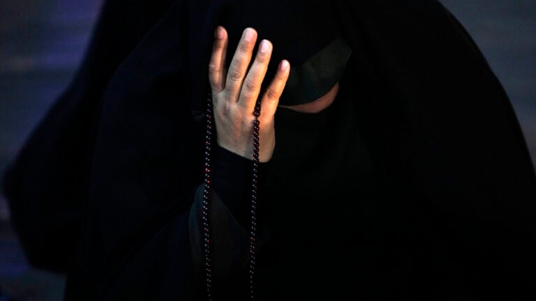 An Iranian woman prays for President Ebrahim Raisi in a ceremony at Vali-e-Asr square in downtown Tehran, Iran.