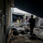 Displaced Palestinians inspect their tents destroyed by Israel's bombardment.