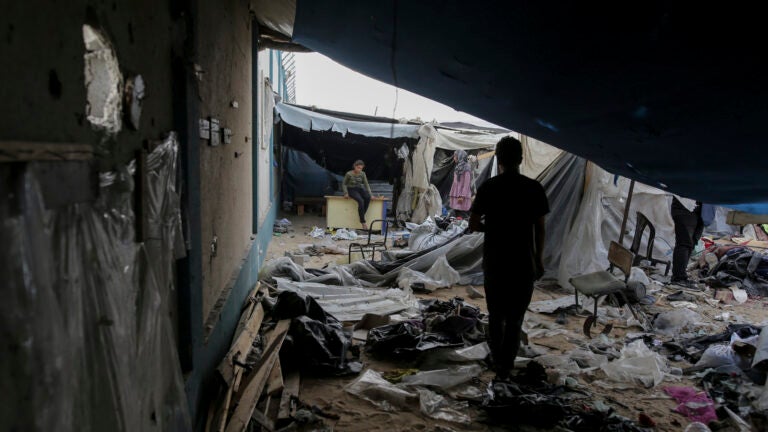 Displaced Palestinians inspect their tents destroyed by Israel's bombardment.