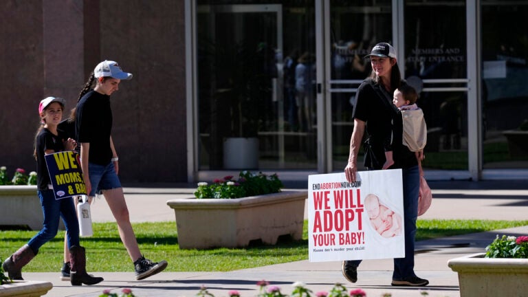 FILE - Pro-life demonstrators walk in the front of the Arizona Capitol prior to the vote on the proposed repeal of the state's near-total ban on abortions prior to winning approval from the state House on, April 24, 2024, in Phoenix.