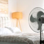 Modern electric fan in bedroom. Space for text