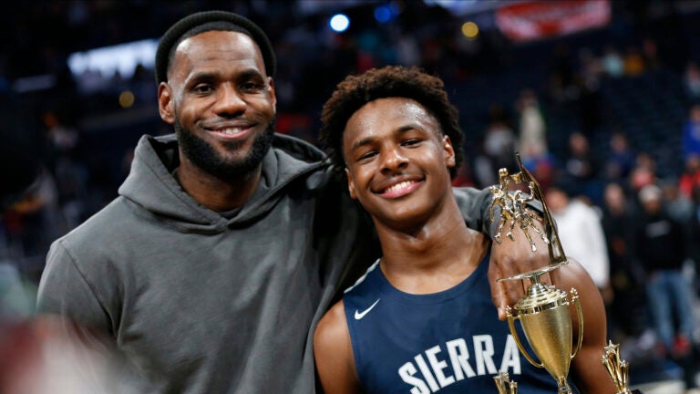 LeBron James, left, poses with his son Bronny after Sierra Canyon defeated Akron St. Vincent - St. Mary in a high school basketball game Saturday, Dec. 14, 2019, in Columbus, Ohio.  Bronny James, son of NBA superstar LeBron James, was hospitalized after suffering cardiac arrest while participating in a workout in Southern California on Monday, July 24, 2023.