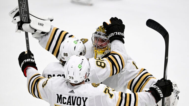 Boston Bruins goaltender Jeremy Swayman (1) celebrates with right wing David Pastrnak (88) and defenseman Charlie McAvoy (73) after the team's shootout win against the Washington Capitals in an NHL hockey game Saturday, March 30 2024, in Washington.