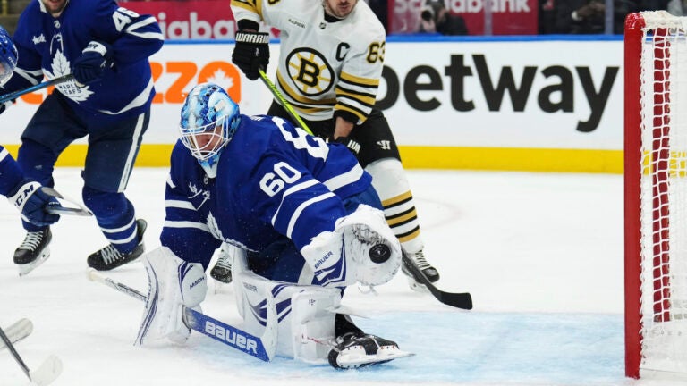 Toronto Maple Leafs goaltender Joseph Woll (60) makes a save as Boston Bruins' Brad Marchand (63) looks on during third-period action in Game 6 of an NHL hockey Stanley Cup first-round playoff series in Toronto, Thursday, May 2, 2024.