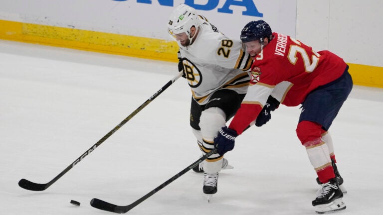 Boston Bruins defenseman Derek Forbort (28) and Florida Panthers center Carter Verhaeghe (23) go after the puck during the first period of an NHL hockey game, Wednesday, Nov. 22, 2023, in Sunrise, Fla.