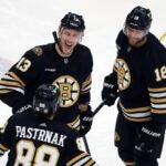 Boston Bruins' Charlie Coyle (13) celebrates after his goal with Pavel Zacha (18) and David Pastrnak (88) during the second period of an NHL hockey game against the Anaheim Ducks, Thursday, Oct. 26, 2023, in Boston.