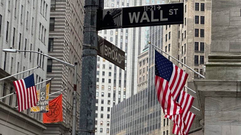 FILE - American flags hang from the front the New York Stock Exchange, right, in New York.
